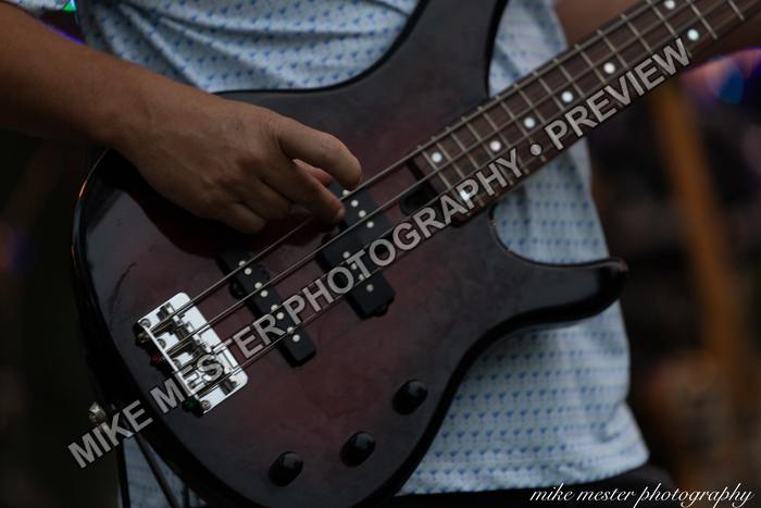 Close view of a bass guitar being played on stage.