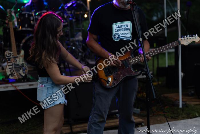 Female and male guitarists performing together on stage.