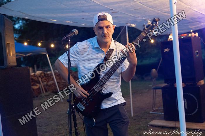 Bass guitarist performing near the front of the stage.