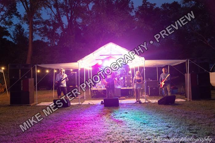 Wide view of the illuminated outdoor stage at night.